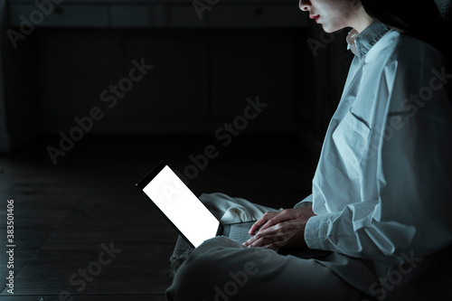 Woman use laptop in dark room.