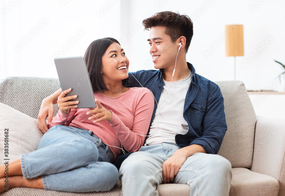 Chinese Couple Using Tablet Watching Movie Sitting Of Sofa Indoor Chinese Couple Using Tablet Watching Movie Sitting Of Sofa Indoor