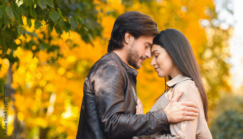 Romantic lovers embracing and touching each other with foreheads