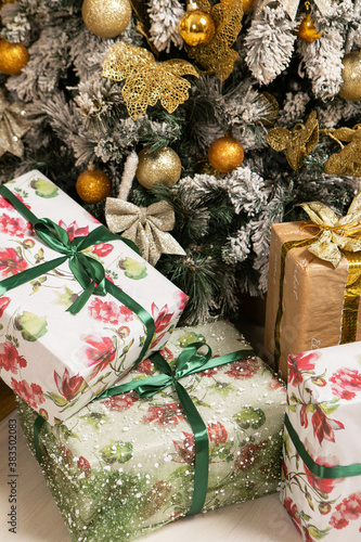 Decorated xmas presents laid out under the Christmas tree. Bright Christmas gifts in decorative boxes © Artem Bruk