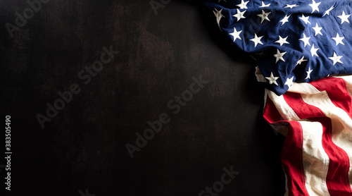 Happy Veterans Day concept. American flags against a dark stone background. November 11. © Siam