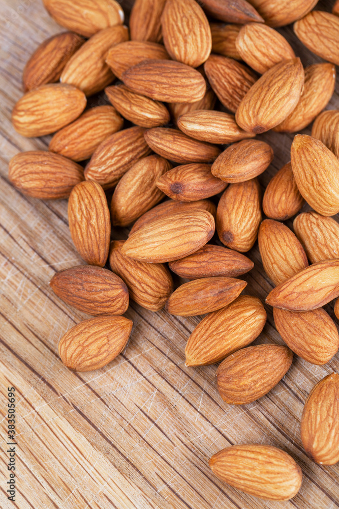 Detail shot of many almonds on a wooden background Detail shot of many almonds on a wooden background
