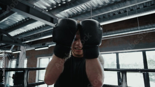 Victory fighter screaming in fitness center. Sportsman showing power on ring