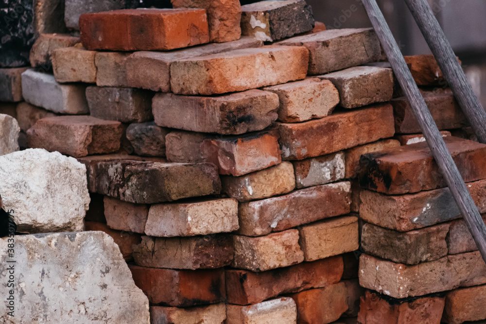 Bricks for construction. A lot of old red and orange bricks are stacked on top of each other. Bricks for construction. A lot of old red and orange bricks are stacked on top of each other.