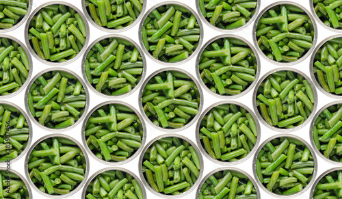 Seamless food background of flat lay view at opened tin cans with green beans isolated on white background. Clipping path added