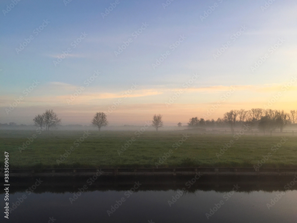 river near meadow at sunrise in the village of Giethoorn, Holland Netherlands river near meadow at sunrise in the village of Giethoorn, Holland Netherlands