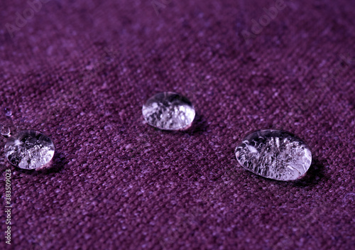 Water drops on purple fabric.