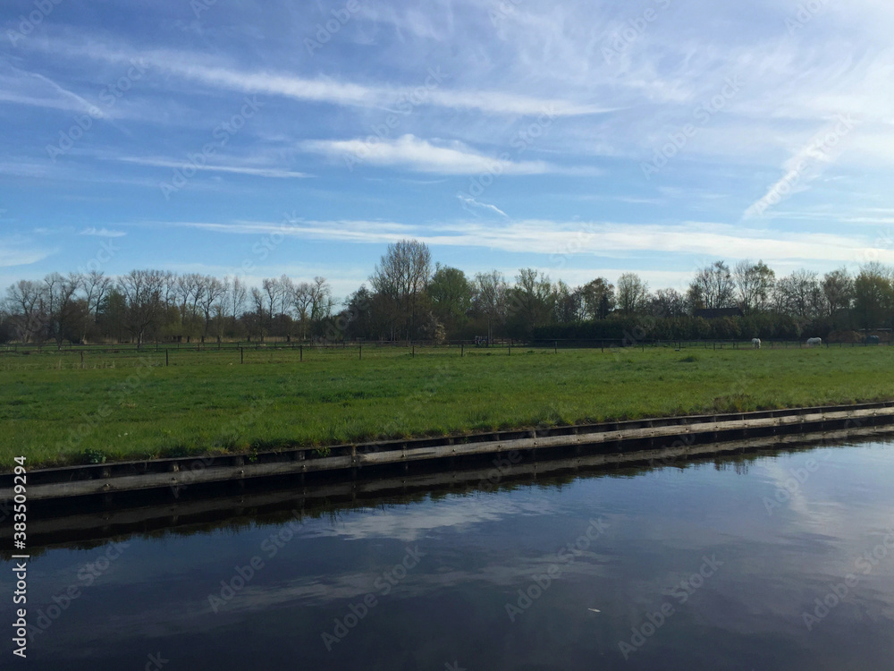 Obraz premium the river near meadow against blue sky in the village of Giethoorn, Holland Netherlands
