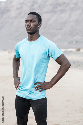 Serious ethnic athlete standing on beach © Juan Algar
