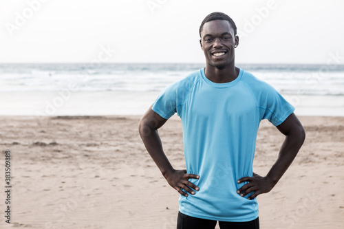 Happy African American sportsman on beach © Juan Algar