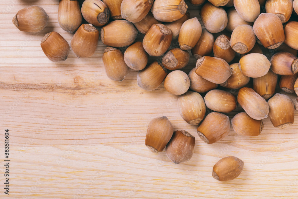 Pile of nuts. Whole nuts. Corylus avellana. Macro photo, close up, top view on wooden table. Pile of nuts. Whole nuts. Corylus avellana. Macro photo, close up, top view on wooden table.