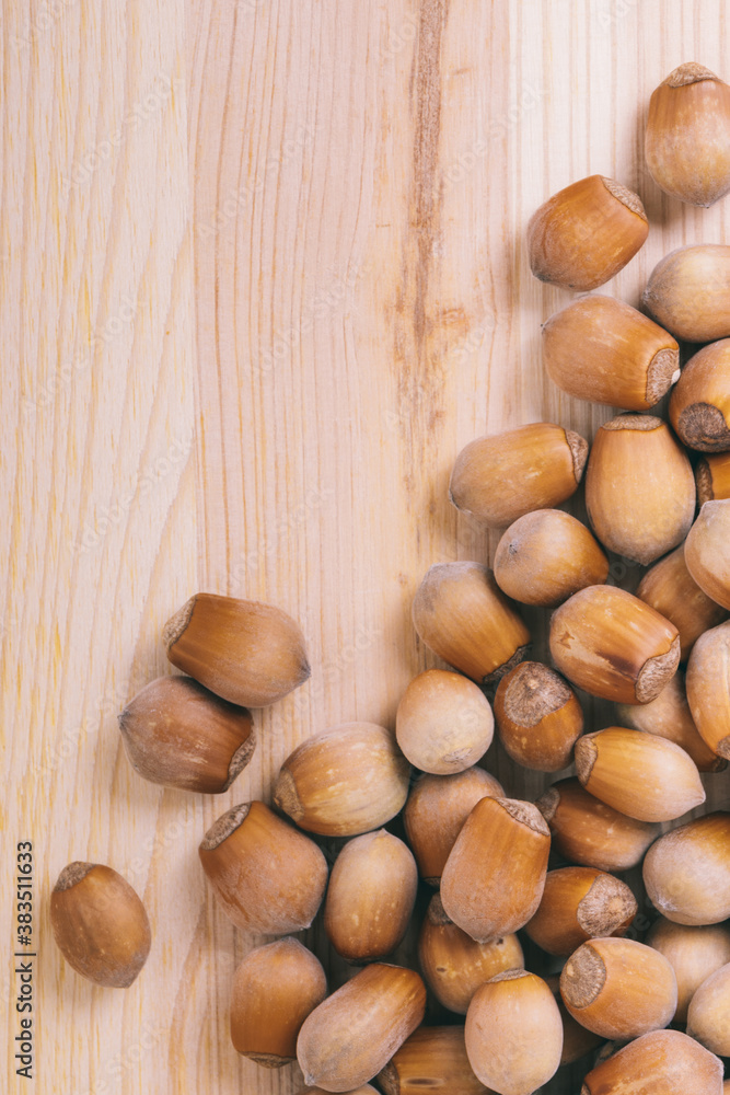 Pile of nuts. Whole nuts. Corylus avellana. Macro photo, close up, top view on wooden table. Pile of nuts. Whole nuts. Corylus avellana. Macro photo, close up, top view on wooden table.