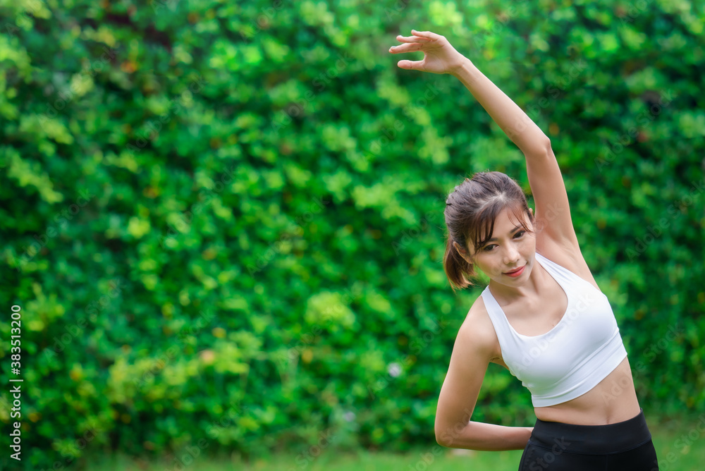 Young asian women warm up in a park before jogging. Young asian women warm up in a park before jogging.