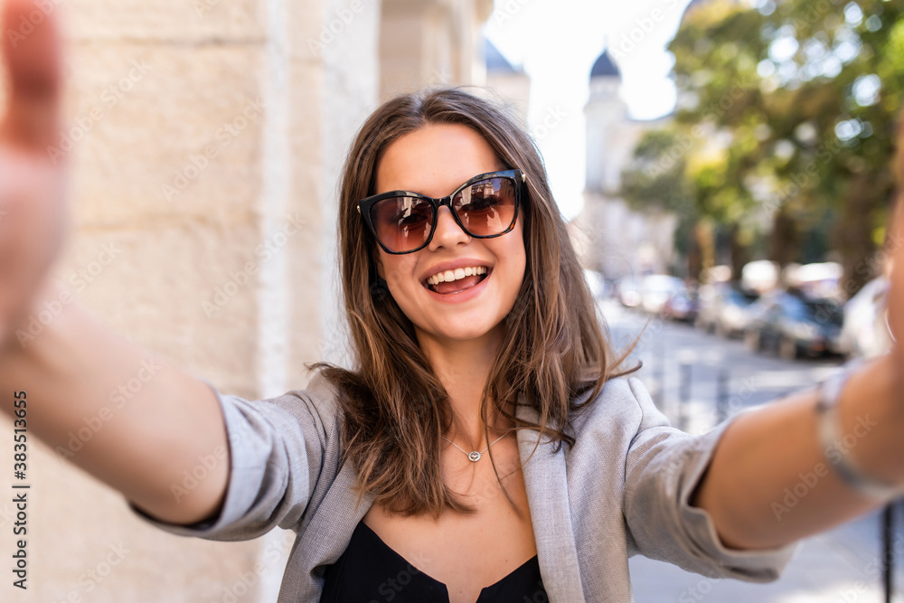 Pretty young woman takes a selfie in the city street Pretty young woman takes a selfie in the city street