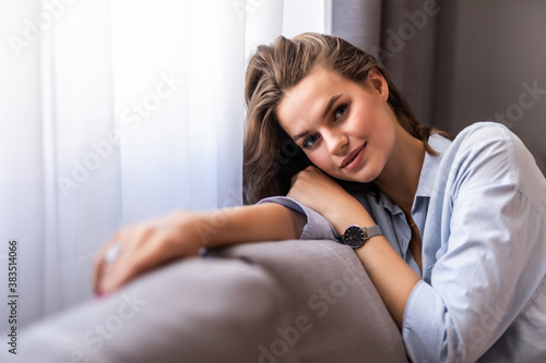 Happy woman relaxing on comfortable soft sofa enjoying stress free weekend at home