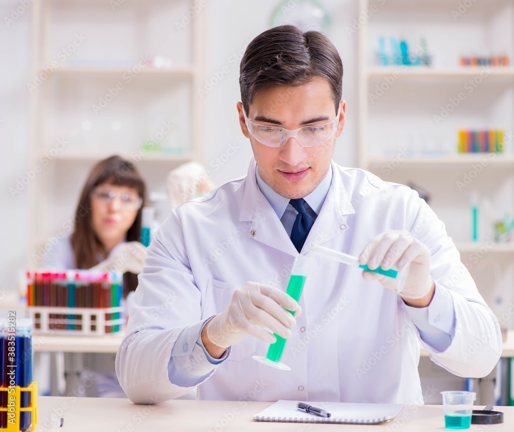 Two chemists working in lab experimenting Two chemists working in lab experimenting