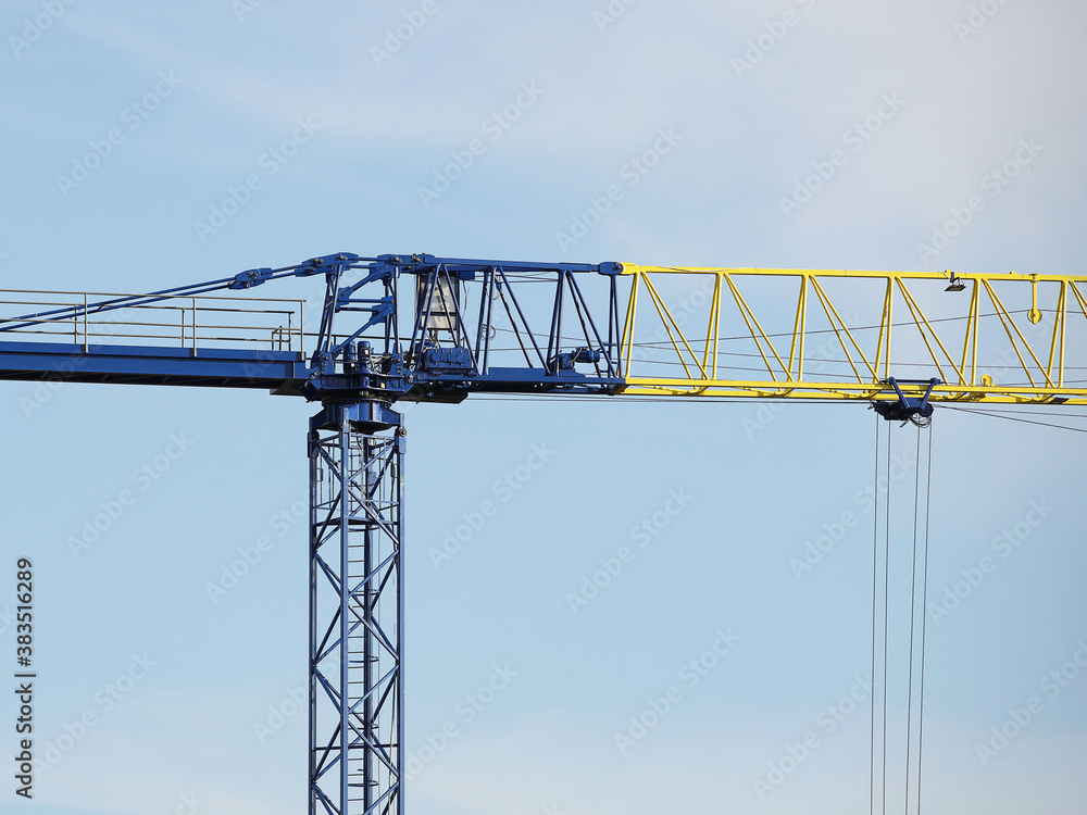 Tower cranes work during the construction of a multi-story building. New apartments for residents and premises for offices. Risky work at height. Lifting heavy building materials. City development