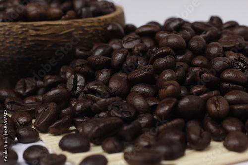 pile of roasted coffee beans, exotic black and emitting a distinctive aroma of coffee.