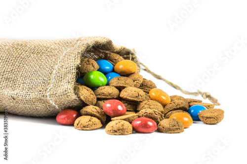 Colorful pepernoten treats in jute bag on white background photo