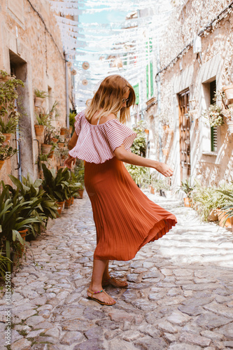 Blonde woman in long skirt dancing in Valdemossa, Majorca. Summertime. photo