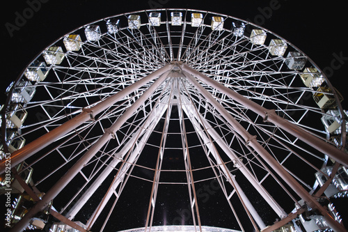 Illuminated Ferris wheel in city during night photo