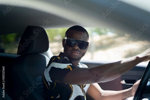 young african man driving his white car photo