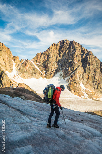 Side view of backpacker crossing a high mountain pass photo