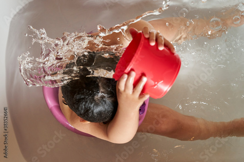 Kid washing her head in the shower.