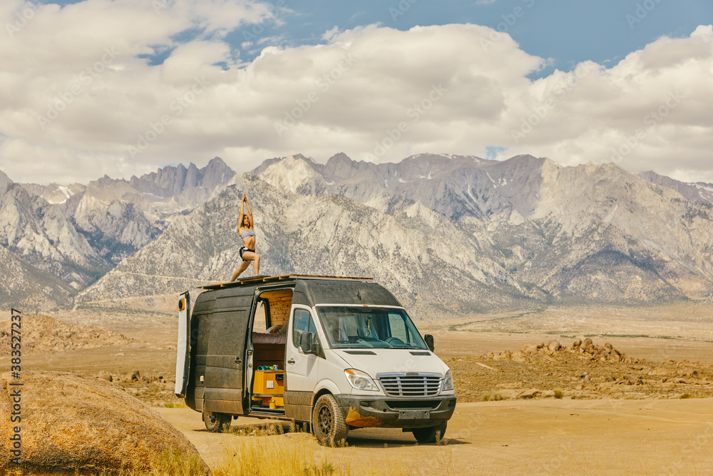 Woman practicing yoga on roof of camper van in northern California. Woman practicing yoga on roof of camper van in northern California.