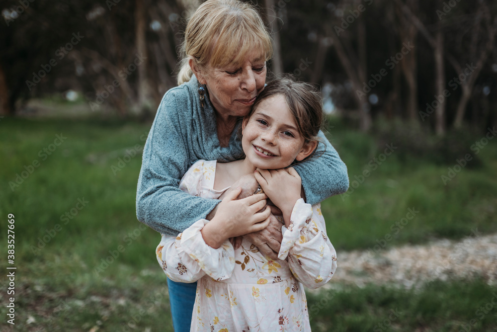 Close up of grandmother and granddaughter smiling in field Close up of grandmother and granddaughter smiling in field