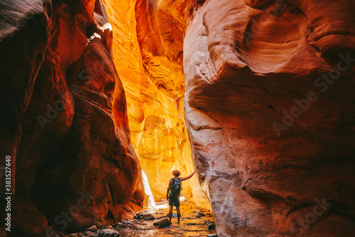 Young man wearing a hat, exploring a slot canyon in Kanarra Fall, Utah