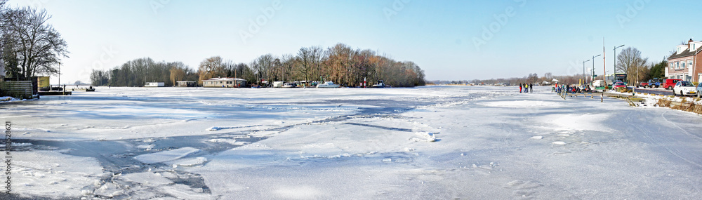 Ice skaters preparing for a trip on frozen lake Kaag (Netherlands)  