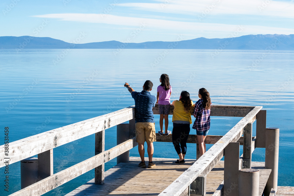 A family on a pier on a beautiful day in South Lake Tahoe, CA A family on a pier on a beautiful day in South Lake Tahoe, CA