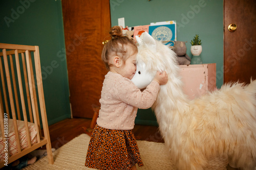 Toddler girl hugging her stuffed animal happily photo