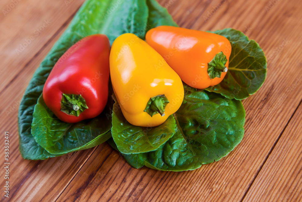three sweet peppers on wooden table background three sweet peppers on wooden table background