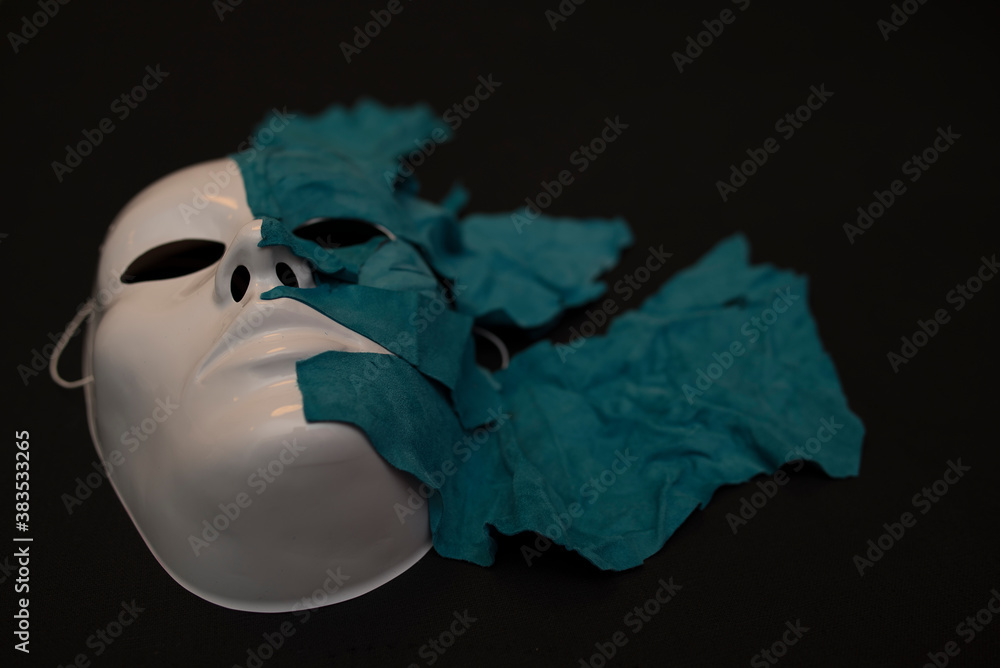 Naklejka premium White theater mask on a black background covered with leather flaps. Psychic symbol of overlapping layers.