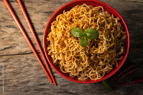 instant noodles in the red bowl on wooden background
