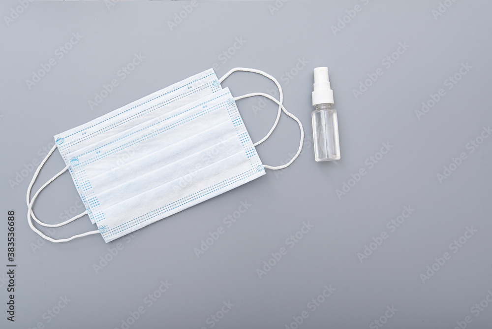 Surgical mask, medical mask and alcohol antibacterial antiseptic hand gel on gray background, concept picture Surgical mask, medical mask and alcohol antibacterial antiseptic hand gel on gray background, concept picture