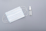 Surgical mask, medical mask and alcohol antibacterial antiseptic hand gel on gray background, concept picture