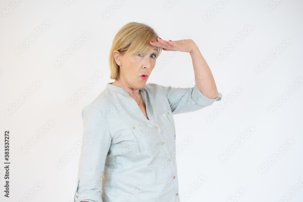 Senior woman with surprised expression on her face over yellow background Senior woman with surprised expression on her face over yellow background