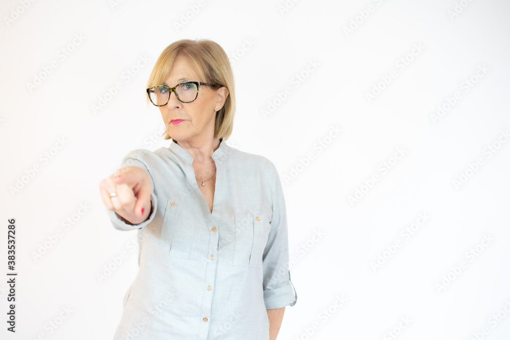 Senior woman pointing on a white background Senior woman pointing on a white background