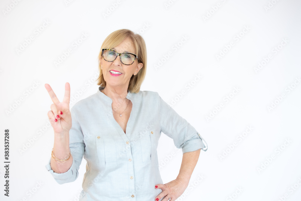 Beautiful senior woman over isolated background smiling with happy face winking at the camera doing victory sign. Number two. Beautiful senior woman over isolated background smiling with happy face winking at the camera doing victory sign. Number two.