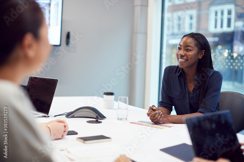 Smiling African American Businesswoman Sitting At Table In Office Meeting Room
