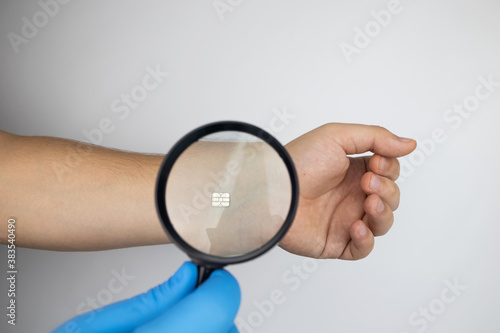 The cosmetic surgeon examines the patient's hand with a biological chip through a magnifying glass. The concept of cybernetics, biotechnology and high-tech future. Isolated on white