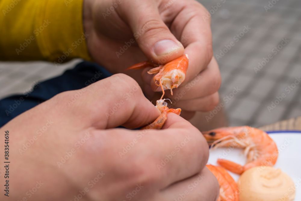 Obraz premium The guy in the yellow jacket is eating shrimp