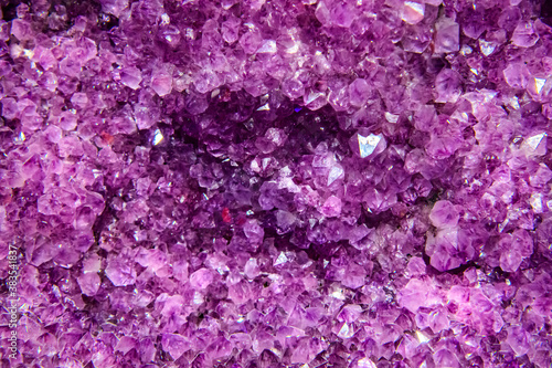 Large geode of amethyst crystals. Purple palette. Soft selective focus.