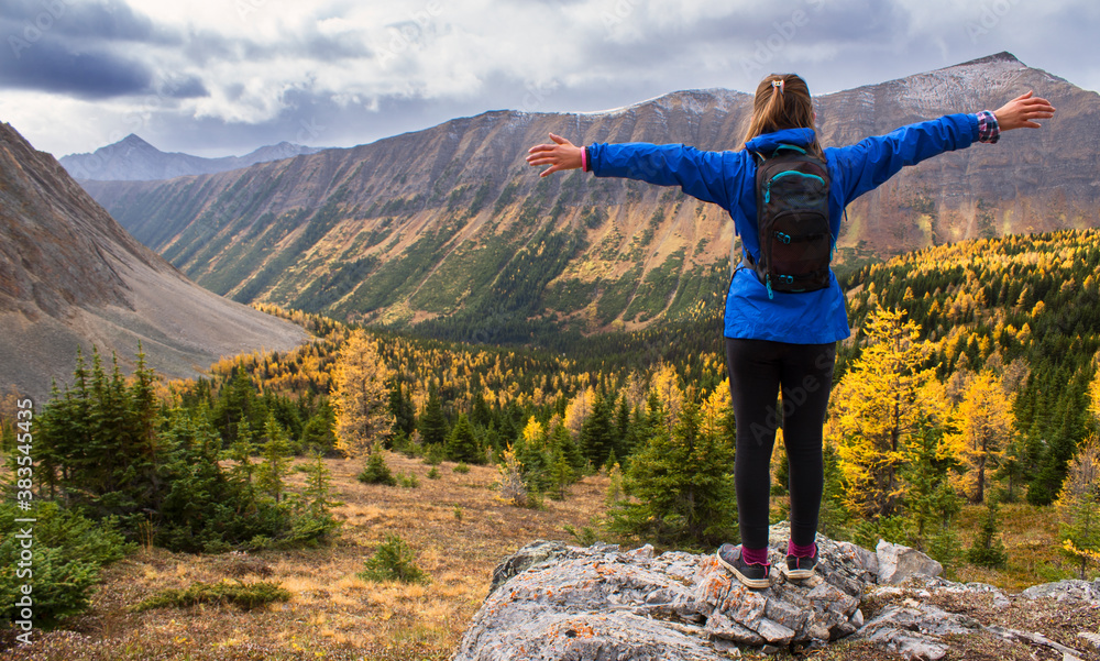 Φωτογραφία A hiker embracing a viewpoint hike with larch trees in autumn colours near Banff National Park Alberta Canada