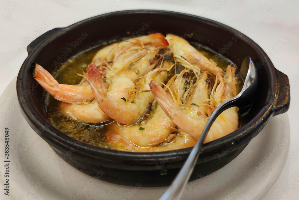 King prawns flambeed with brandy presented in a clay pot King prawns flambeed with brandy presented in a clay pot