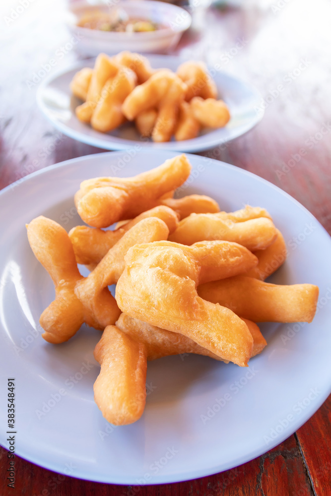 Chinese bread stick or chinese donut on dish. Breakfast street food usually eat with hot tea, coffee or soy milk. Chinese bread stick or chinese donut on dish. Breakfast street food usually eat with hot tea, coffee or soy milk.