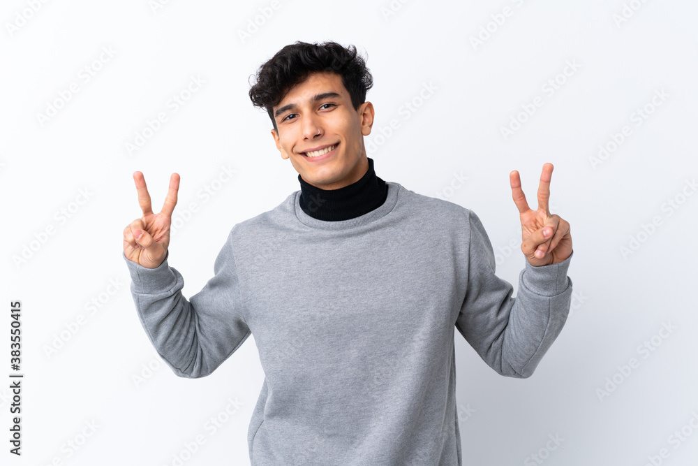 Young Argentinian man over isolated white background showing victory sign with both hands Young Argentinian man over isolated white background showing victory sign with both hands
